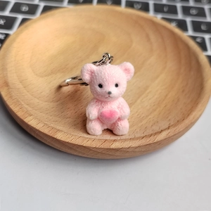 Detail view of pink flocked teddy bear keychain with pink heart and silver metal clasp