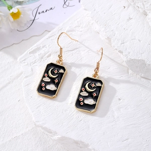 Golden alloy tarot drop earrings featuring black enamel moon and star charms