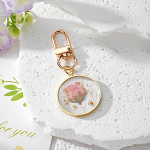 Handmade clear resin daisy keychain with dried pink flowers and gold foil accents