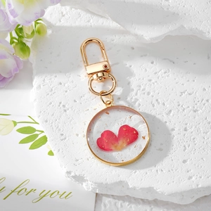 Handmade gold circle keychain with transparent resin heart and red flower petals