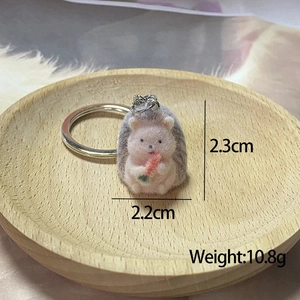 Close-up of mini pink hedgehog plush keychain with carrot, dimensions 2.3cm by 2.2cm