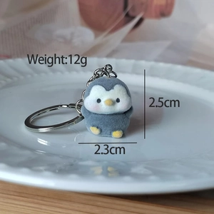Close-up of small flocked penguin keychain showing dimensions 2.5x2.3cm and 12g weight