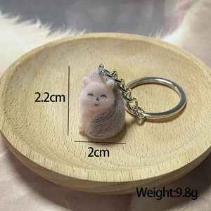 Macro detail of a 2.2cm miniature pink and grey flocked cat keychain with metal ring