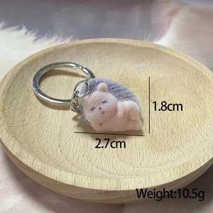 Miniature sleeping hedgehog charm measuring 2.7cm by 1.8cm with silver keychain ring