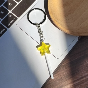 Translucent yellow star lollipop keychain with glitter resin on a silver metal ring