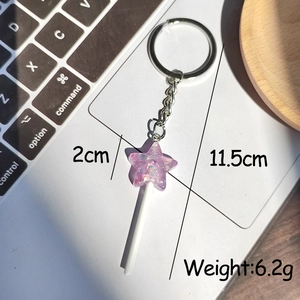 Detail shot showing purple resin star lollipop keychain with glitter and silver metal ring