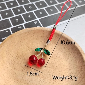 Detailed view of red resin cherry charm with braided cord showing 1.8cm x 10.6cm dimensions
