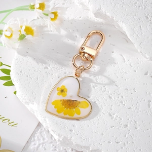 Handmade heart-shaped gold keychain with yellow dried flowers and a spring buckle