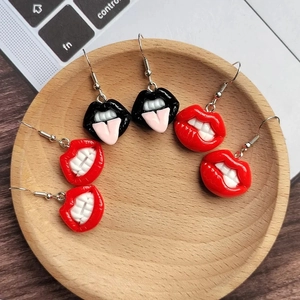 Nahaufnahme von Harzohrringen in Lippenform auf einem Holztablett mit Lifestyle-Hintergrund