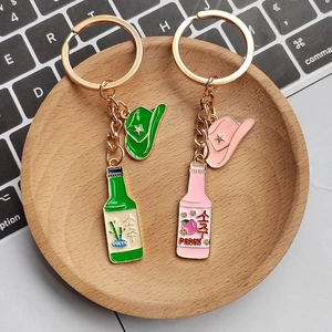 Detail von kreativen Schlüsselanhängern mit Soju-Flasche und Cowboyhut in Pink und Grün
