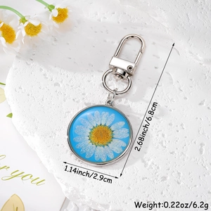 Détail d'un porte-clés marguerite séchée en résine bleue avec dimensions du produit