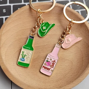 Kreative Emaille-Schlüsselanhänger mit Cowboyhut und Soju-Flasche in Grün und Rosa