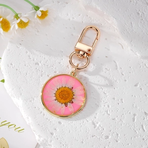 Porte-clés doré exquis avec véritable fleur de marguerite blanche dans un pendentif