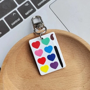 Dettaglio di un portachiavi a tavolozza in acrilico con cuori colorati su legno
