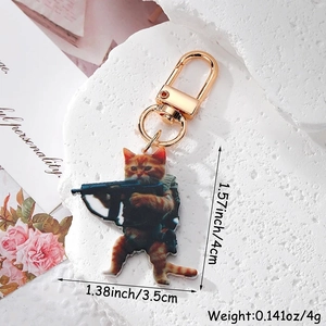 Detail view of acrylic orange cat keychain with tactical gear and gold lobster clasp