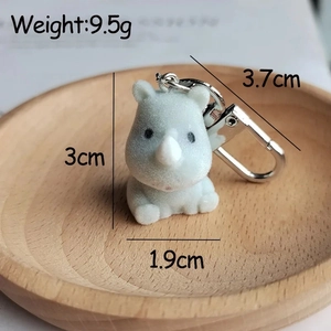 Detail of blue plush rhino keychain showing soft flocking texture and silver metal buckle