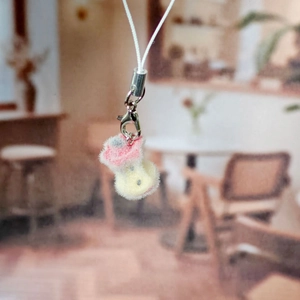 Detailed macro view of a pink and yellow flocked apple heart pendant with silver clasp