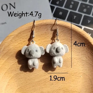 Detail view of gray flocked koala earrings with silver hooks and size dimensions
