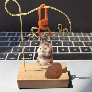 Detail of pink flocked squirrel charm with nut and orange metal lobster clasp