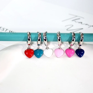 Detail view of six heart-shaped hoop earrings in vibrant colorful enamel finishes