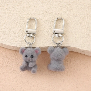 Close-up of cute grey flocked koala keychain with pink ears and silver metal clasp