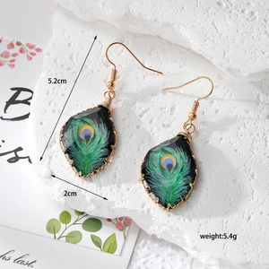 Detail showing peacock feather drop earrings with dimensions of 5.2cm height and 2cm width