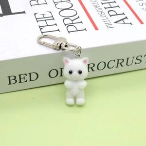 Detail of white flocked kitten keychain with pink ears on silver metal spring clasp