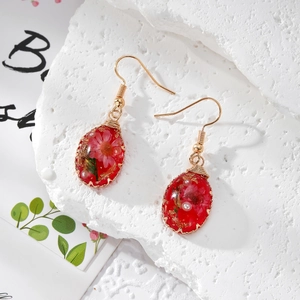 Handmade dried flower resin earrings with gold wire wrap and pearls on white stone