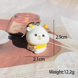 Detailed view of a mini flocked cow keychain with 2.1x2.9cm dimensions and weight info