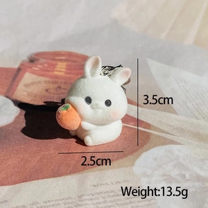 Macro shot of a flocked white rabbit keychain holding an orange with size details