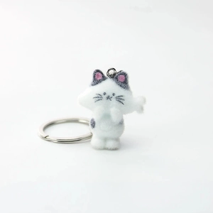 Dettaglio portachiavi gattino bianco floccato con texture morbida e anello in metallo argento