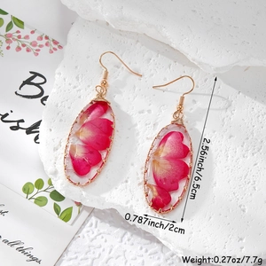 Détail des boucles d'oreilles en résine de fleurs séchées avec fil d'or et mesures de 6,5 cm