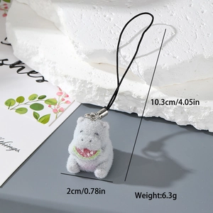 Detailed close-up of a grey flocked hippo keychain holding a tiny watermelon slice