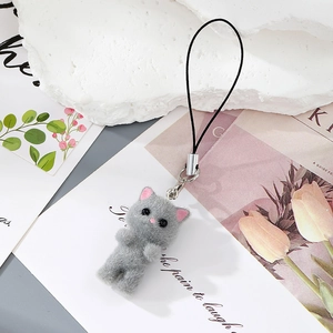 Detailed close-up of a grey flocked kitten charm with silver metal ring and black lanyard