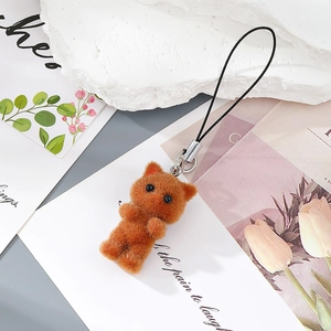 Detail of reddish-brown flocked cat keychain with soft furry texture and black metal lanyard