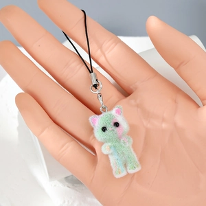 Detailed macro view of a fuzzy green kitten charm with a soft flocked texture and silver clip