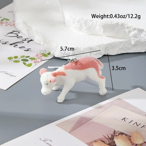 Detalle del colgante mini vaca con medidas 5.7cm x 3.5cm y suave textura flocada