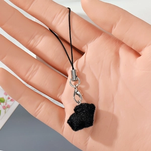 Detail of flocking pig pendant with silver clasp and black lanyard on a hand model