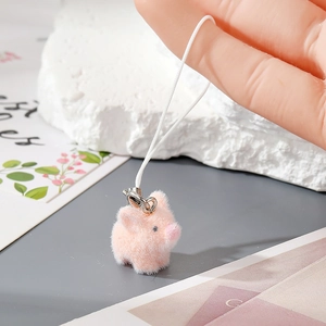 Close-up of a pink flocked pig keychain with soft texture and white hanging cord
