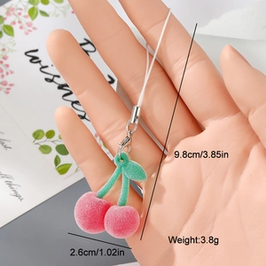 Detail view of a pink flocked cherry charm with green leaves and silver clasp, 9.8cm long