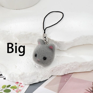 Detail of grey flocked kitten plush charm with fuzzy fur texture and black phone lanyard