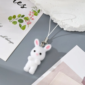 Detail of white flocked resin rabbit keychain with soft texture and white lanyard