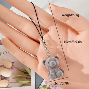 Close-up of a grey flocked resin bear keychain with a silver lobster clasp and black lanyard