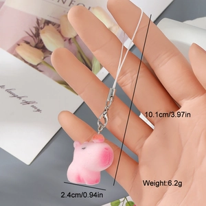 Detail of pink flocked hippo charm with lanyard and metal clasp held in hand