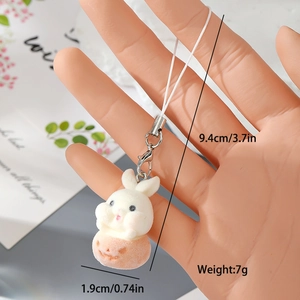 Handheld view of a white flocked bunny keychain with size dimensions and silver clasp