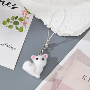 Detail of white flocked kitten charm with soft texture and silver lobster clasp