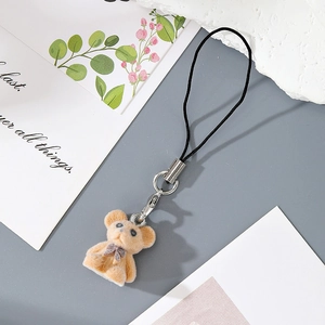 Detailed view of light brown flocked bear keychain with purple polka dot bow and metal clasp