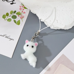 Close-up of fluffy white cat keychain with pink ear details and soft plush texture