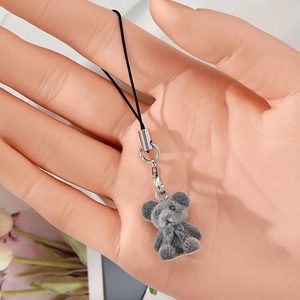 Detail shot of grey flocked bear charm with lobster clasp and black nylon cord