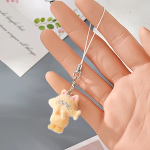 Makroaufnahme von orangefarbenem Katzen-Anhänger mit silbernem Verschluss in der Hand